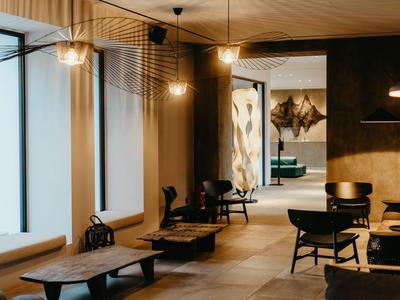 Espace lounge d'hôtel moderne et confortable avec panneaux en bois et design minimaliste.