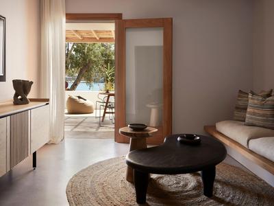Salon moderne avec canapé, table basse et vue sur un balcon avec des arbres.