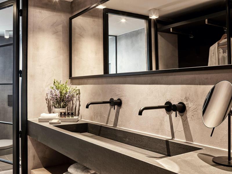 Lavabo moderne double avec miroirs et robinetterie noire dans une salle de bain élégante.