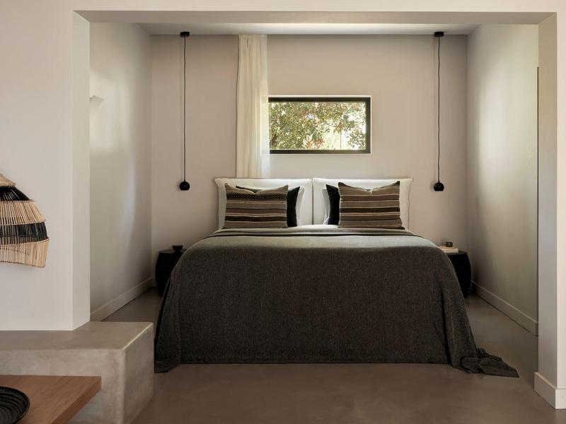 Lit double confortable dans une niche au design minimaliste avec lumière chaleureuse.