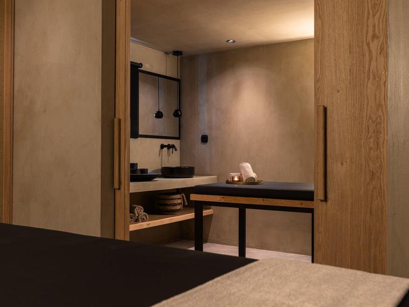 Espace bien-être moderne avec sauna, bancs en bois et éclairage tamisé.