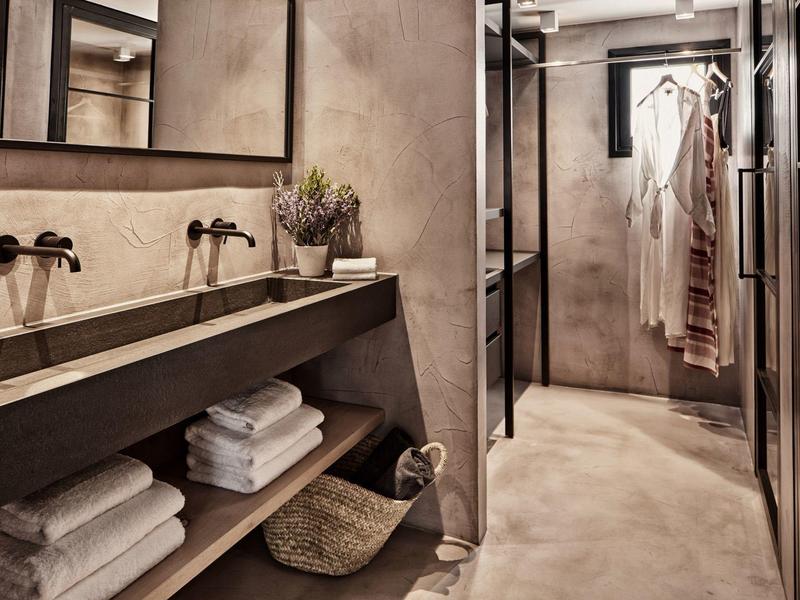 Salle de bain moderne avec double vasque, serviettes et peignoir dans des tons neutres.