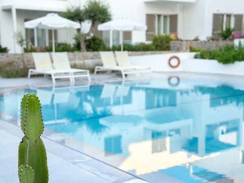Piscina moderna dell'hotel con lettini e ombrelloni in un ambiente tranquillo.
