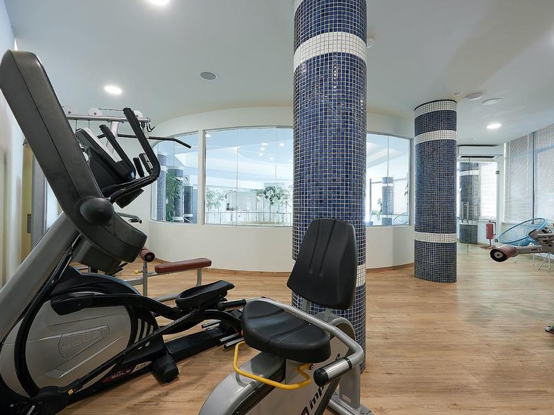Modern gym with various exercise equipment and wooden flooring