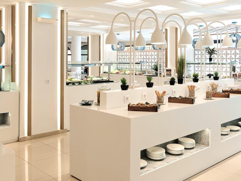 Bright, modern buffet with white counters and multiple food stations in an elegant setting.