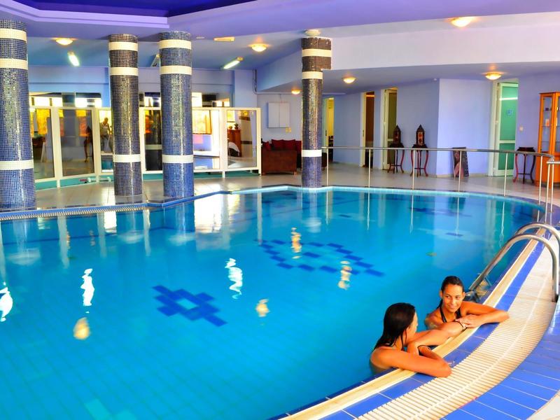 Indoor round pool with blue lighting and plants in a modern hotel