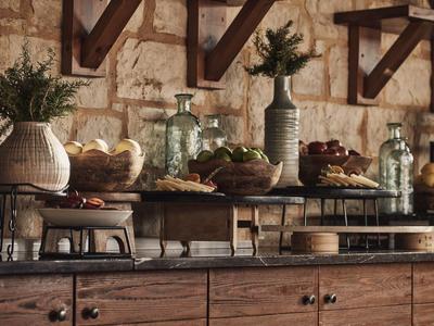 Rustikales Buffet mit Brot, Obst und Vasen in einem warm beleuchteten Hotelrestaurant.