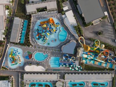 Hotelkomplex mit mehreren Pools, Wasserrutschen und umliegenden Gebäuden aus der Vogelperspektive.
