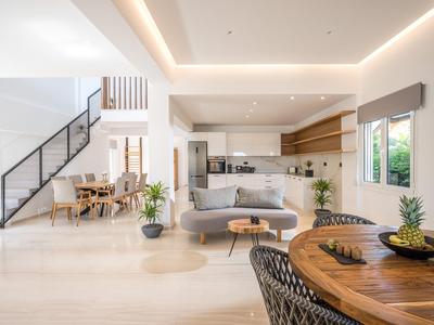 Sala de estar moderna y luminosa con cocina abierta, comedor y mesa decorada.