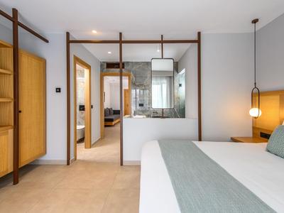 Nowoczesny pokój hotelowy z wygodnym łóżkiem, drewnianymi meblami i jasnym oświetleniem.