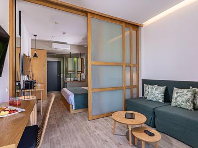 Nowoczesny pokój hotelowy z sypialnią i przytulnym salonem.