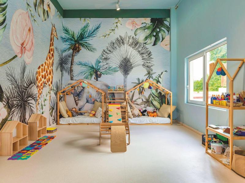 Colorful children's playroom with jungle-themed mural and toys in a bright room.