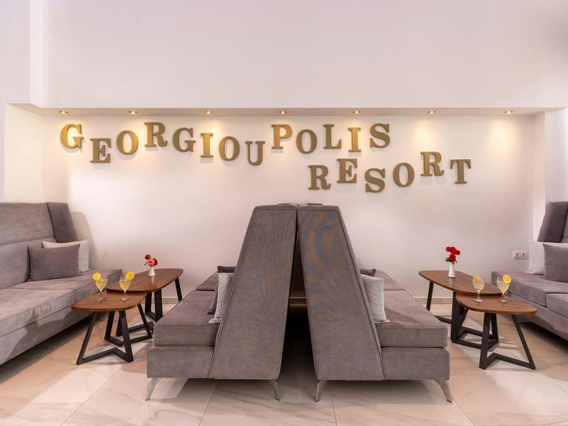 Modern lounge area with gray armchairs and sofas at Georgiou Polis Resort.
