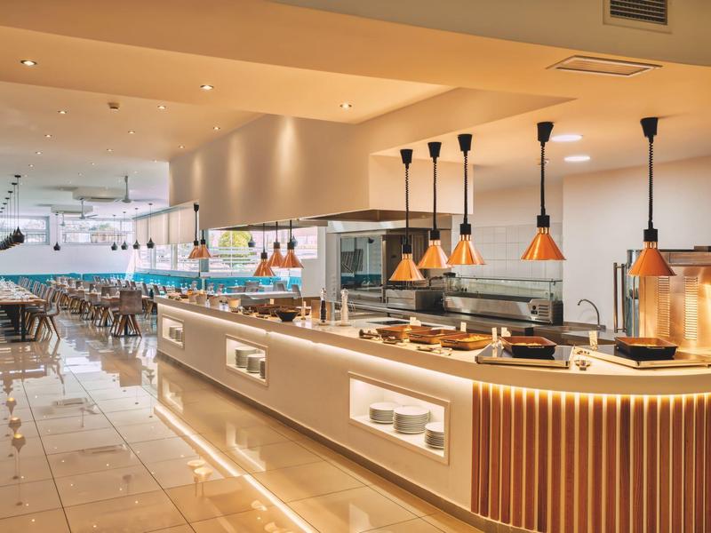 Modern, bright hotel kitchen with buffet and stylish pendant lamps.