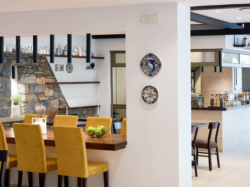 Nowoczesna jadalnia z żółtymi krzesłami i jasną otwartą kuchnią.