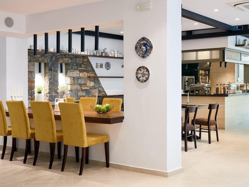 Nowoczesna sala z żółtymi krzesłami, białymi ścianami i prostą dekoracją.