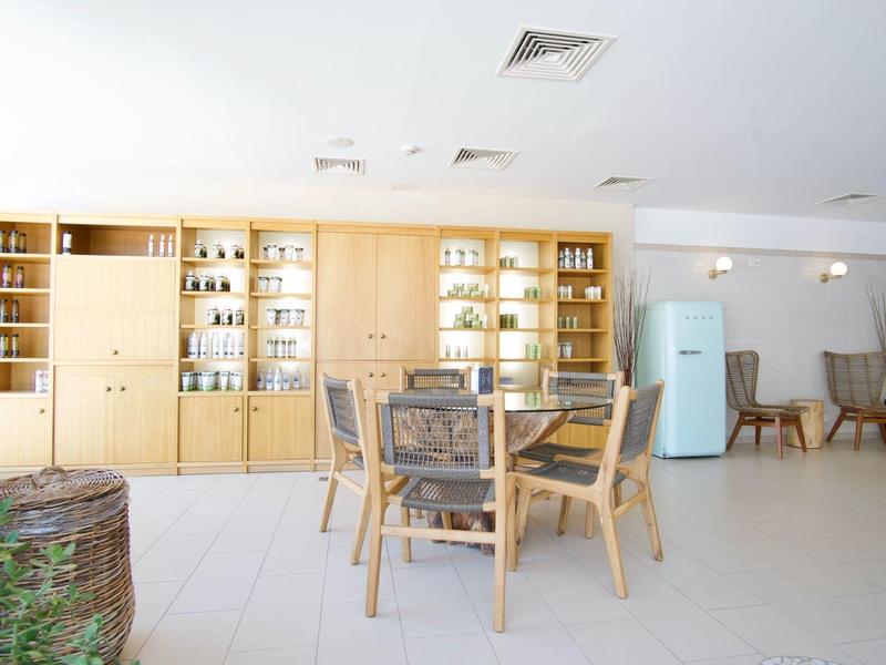 Jasna jadalnia z drewnianym stołem, krzesłami i półkami z dekoracjami.