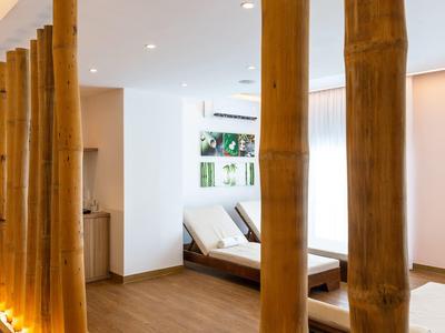 Hotel-Wellnessbereich mit Liegen, warmem Licht und großen Bambusstämmen als Raumteiler.