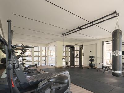 Moderner, heller Fitnessraum mit Laufbändern und Boxsack, ideal für Hotelgäste.