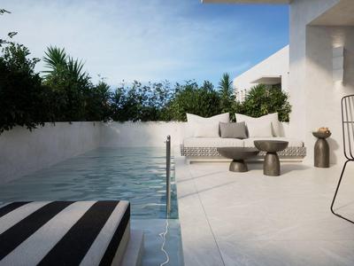 Moderner Poolbereich mit Liege und Sitzgelegenheiten neben einem weißen Gebäude.