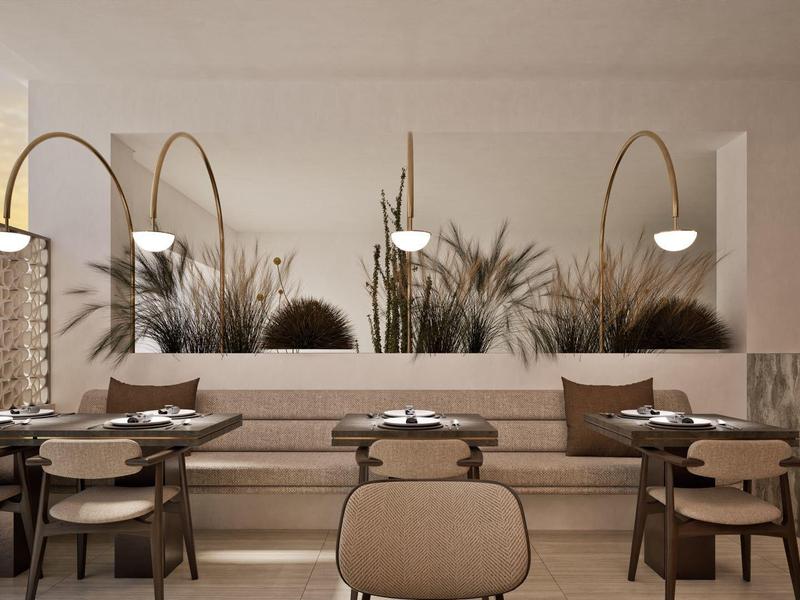 Modern eingerichteter Essbereich mit runden Tischen, gepolsterten Stühlen und dekorativem Pflanzenarrangement.