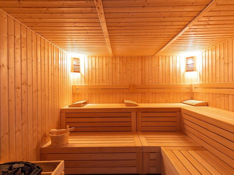 Holzsauna mit Sitzbänken und sanfter Beleuchtung für Entspannung und Wellness.