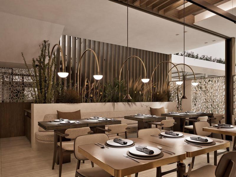 Modernes Restaurant mit Holztischen, bequemen Stühlen und dekorativen Pflanzen im Innenbereich.