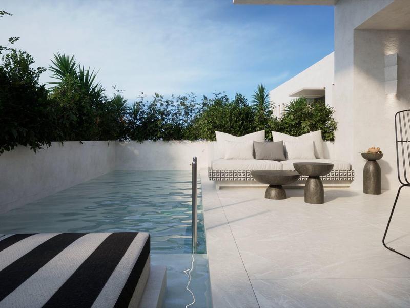 Moderner Poolbereich mit Liege und Sitzgelegenheiten neben einem weißen Gebäude.