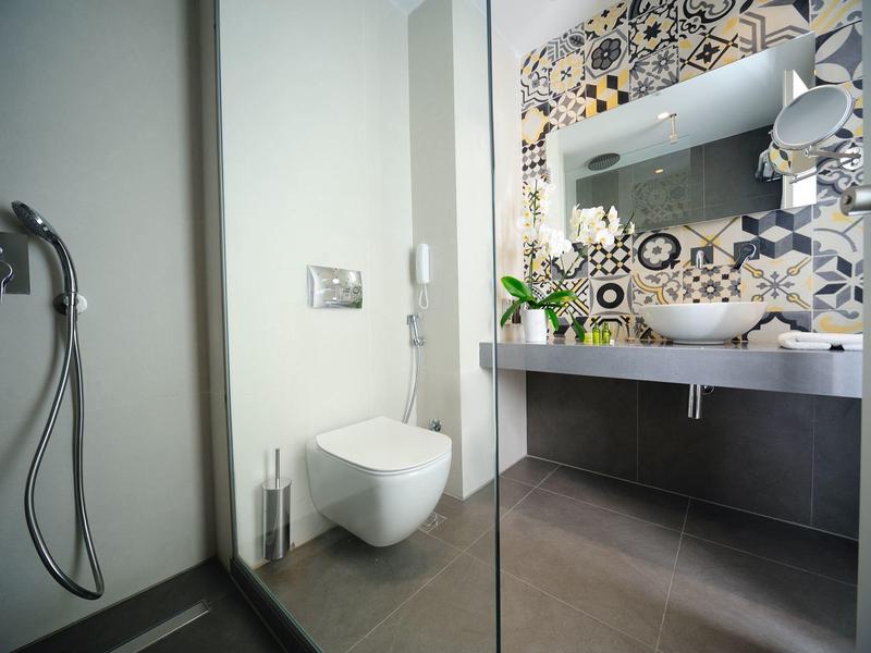 Modernes Badezimmer mit Eckdusche, Wand-WC, großem Spiegel und beigem Waschbeckenunterschrank.