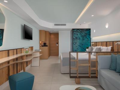 Lounge di hotel moderno con divani, accenti in legno e arte murale astratta.