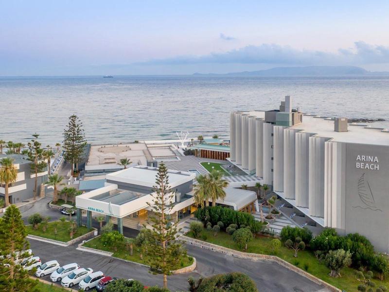 Moderní hotel u moře s bazény a bujnou vegetací.