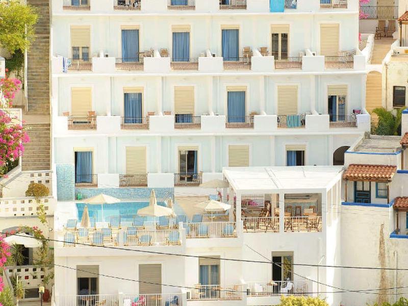 Wielopiętrowy hotel z balkonami, basenem i parkingiem otoczony drzewami.