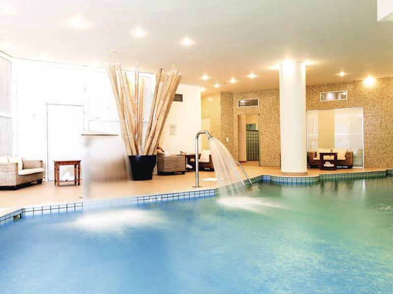 Piscine intérieure d'hôtel avec chaises longues et éclairage doux