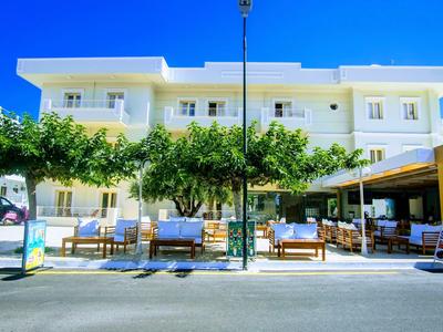 Budynek hotelu z niebieskim niebem, drzewami i miejscami do siedzenia na chodniku