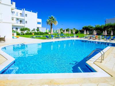 Nowoczesny basen na świeżym powietrzu z leżakami i palmami w hotelu pod bezchmurnym niebem.