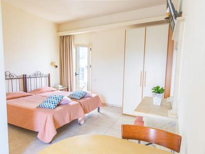 Jasny pokój hotelowy z dwoma łóżkami pojedynczymi, szafą i balkonem