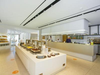 Ristorante a buffet moderno con area pranzo ben illuminata e organizzata.