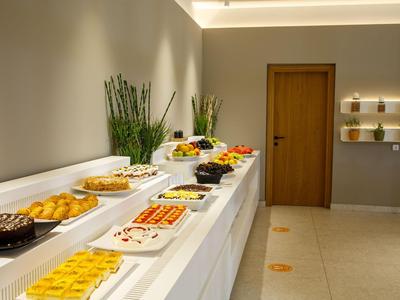 Buffet con vari piatti in una stanza moderna e luminosa con porta in legno e piante.