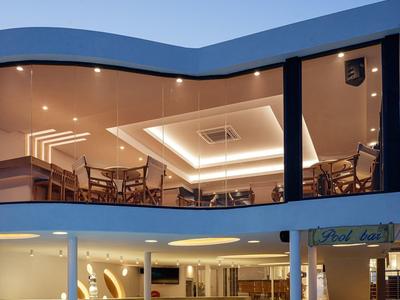 Modern hotel outdoor area with pool, seating, and evening lighting.