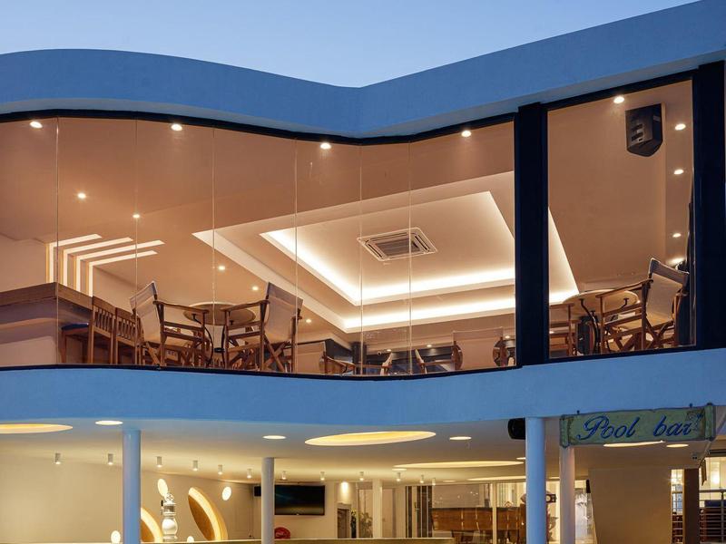 Modern hotel outdoor area with pool, seating, and evening lighting.