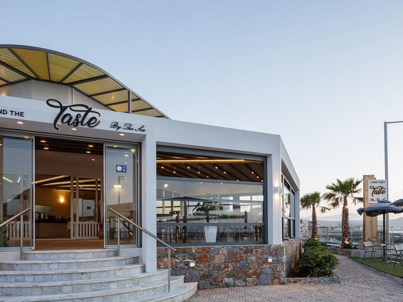 Modern restaurant with large terrace and glass facade in sunny beach location.