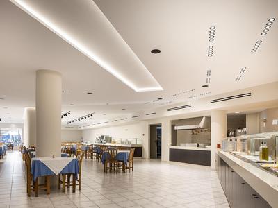 Spacious dining area with set tables and a modern buffet section in a bright setting.