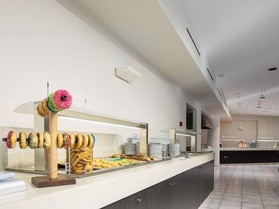 Buffet area with assorted donuts and pastries in a bright hotel restaurant.