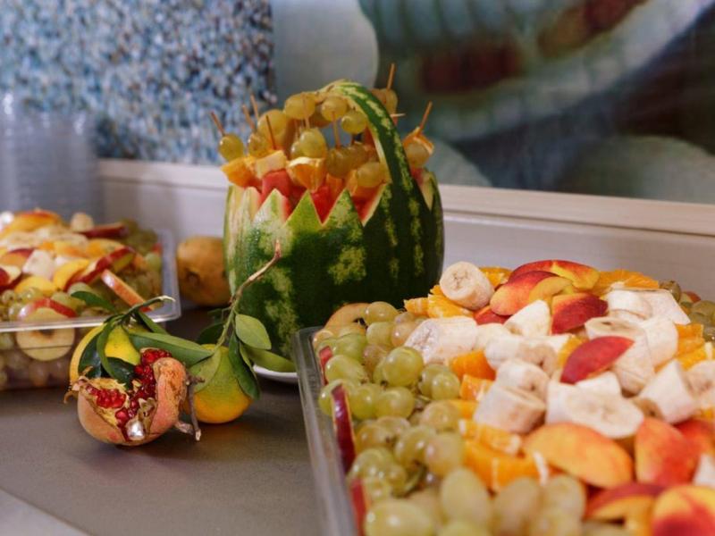 Čerstvé ovoce a vyřezávané melouny na barevném hotelovém bufetu.