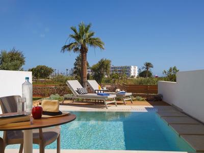 Basen z leżakami i stołem z krzesłem pod niebieskim niebem