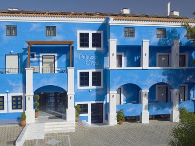 Blauw hotelgebouw met witte kozijnen en meerdere bogen bij de ingang.