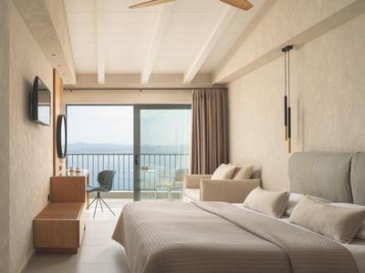 Modernes Hotelzimmer mit Balkon und Meerblick in hellen Farben.