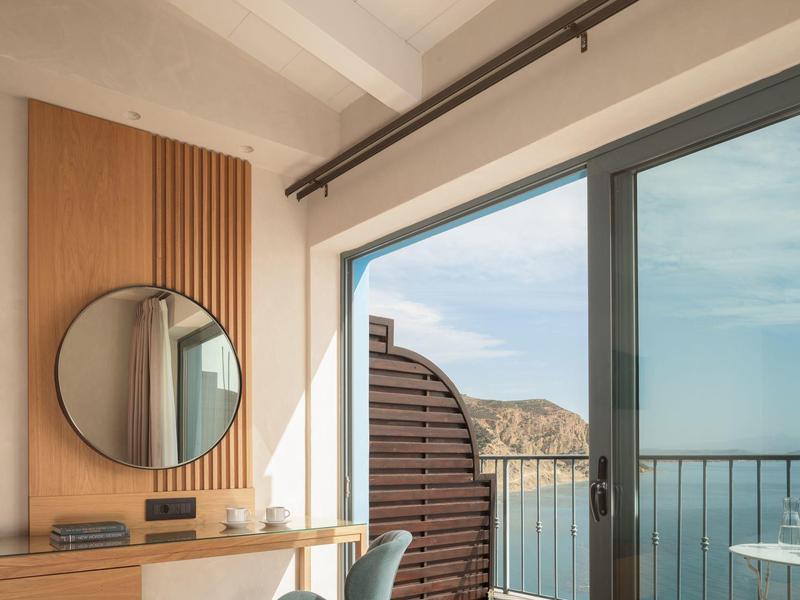 Moderne kamer met balkon en zeezicht bij daglicht.