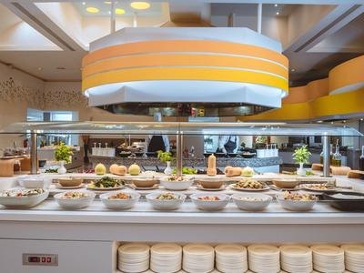 Buffet mit warmen Gerichten und frischem Gemüse in modernem Hotelrestaurant.