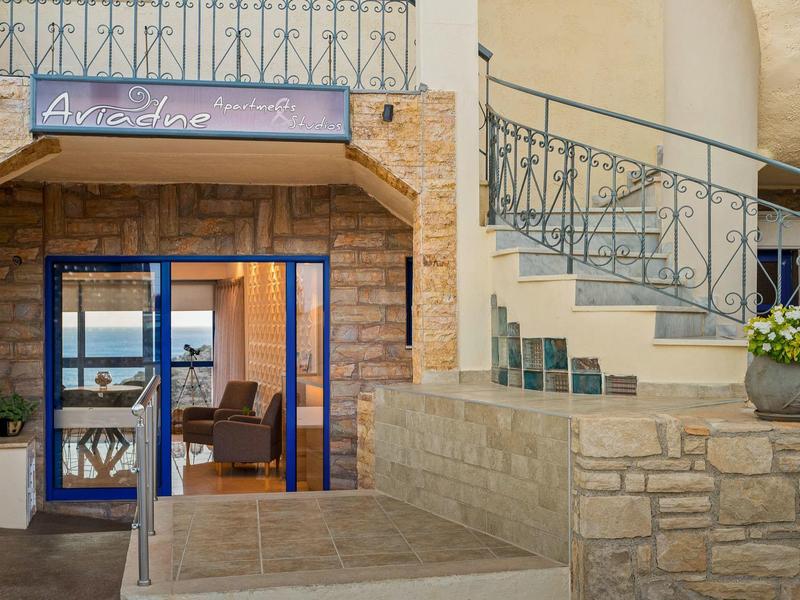 Wejście do hotelu z niebieskimi drzwiami, kamiennymi ścianami i spiralnymi schodami.